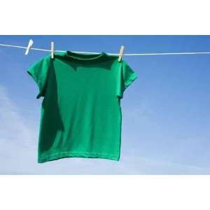  A Green T shirt Hanging on a Clothesline in Front of a Blue Sky 